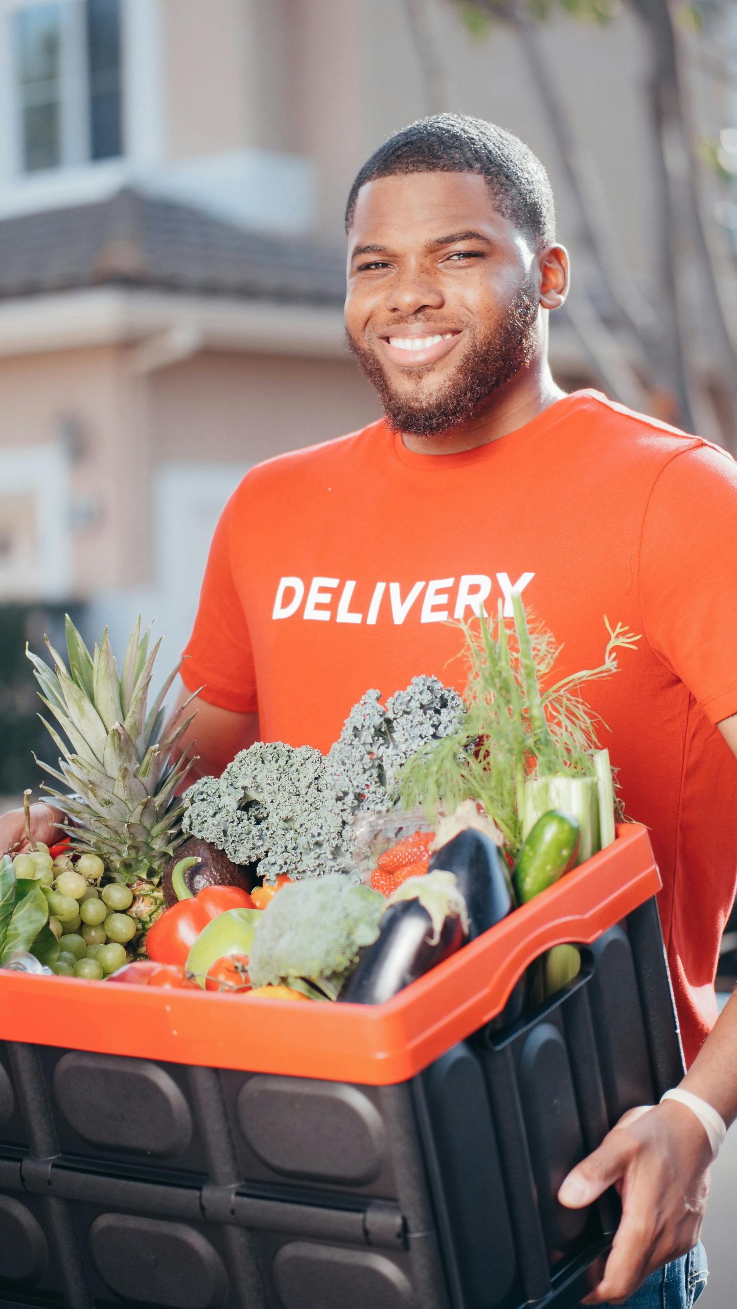 https://www.pexels.com/photo/man-in-orange-shirt-holding-black-and-orange-plastic-box-with-fresh-vegetables-6868797/